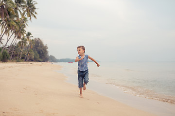 Image showing One happy little boy playing on the beach at the day time.