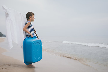 Image showing One little boy playing on the beach at the day time.