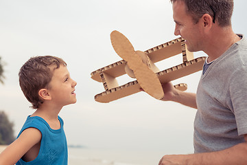 Image showing Father and son playing with cardboard toy airplane