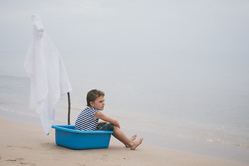 Image showing One little boy playing on the beach at the day time.