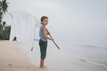 Image showing One little boy playing on the beach at the day time.