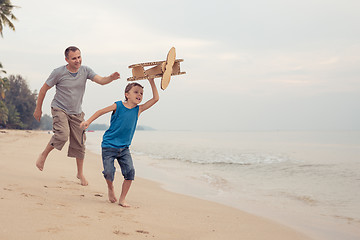 Image showing Father and son playing with cardboard toy airplane