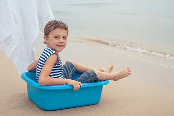 Image showing One happy little boy playing on the beach at the day time.