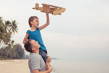 Image showing Father and son playing with cardboard toy airplane