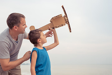 Image showing Father and son playing with cardboard toy airplane