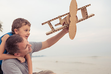 Image showing Father and son playing with cardboard toy airplane