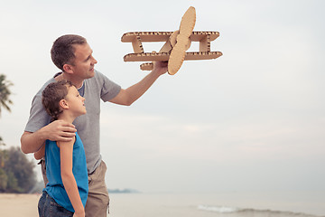 Image showing Father and son playing with cardboard toy airplane