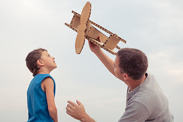 Image showing Father and son playing with cardboard toy airplane