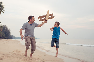 Image showing Father and son playing with cardboard toy airplane