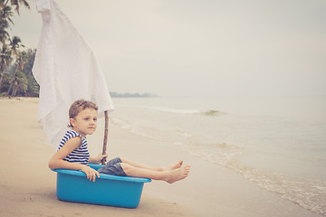 Image showing One happy little boy playing on the beach at the day time.