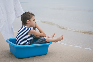 Image showing One little boy playing on the beach at the day time.