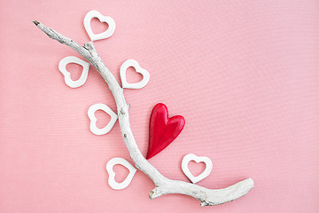 Image showing Driftwood decorated with red and white wooden hearts