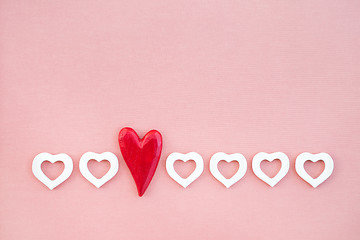 Image showing Row of red and white wooden hearts on pink background