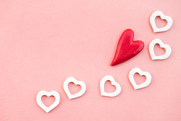 Image showing Red and white wooden hearts on pink canvas