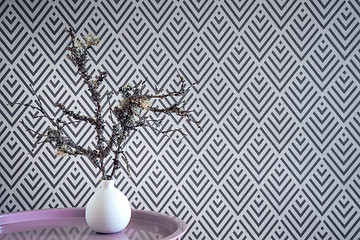 Image showing Mossy twigs in a vase on geometric wallpaper background