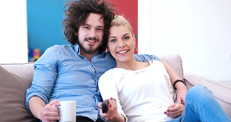 Image showing Young couple on the sofa watching television