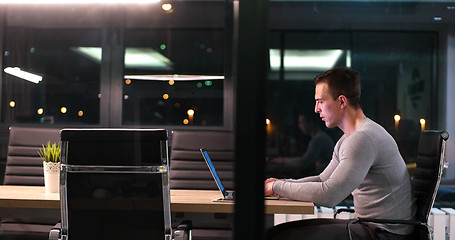 Image showing man working on laptop in dark office