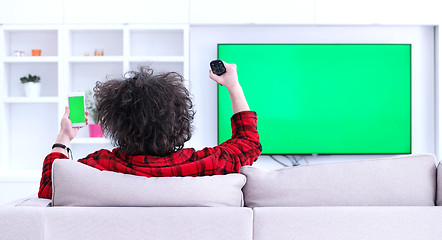 Image showing Young couple on the sofa watching television