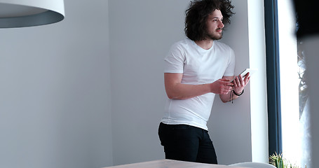 Image showing young man using a tablet at home