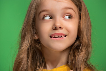 Image showing The happy teen girl standing and smiling against green background.