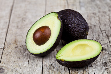 Image showing Fresh organic avocado on old wooden table background. Fresh avoc