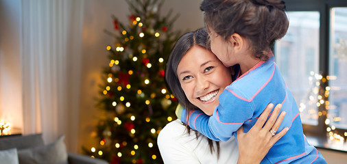 Image showing happy mother hugging her daughter on christmas