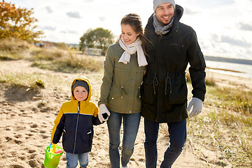 Image showing happy family walking along autumn beach