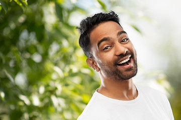 Image showing laughing indian man over green natural background