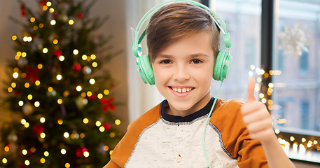 Image showing boy in earphones showing thumbs up on christmas