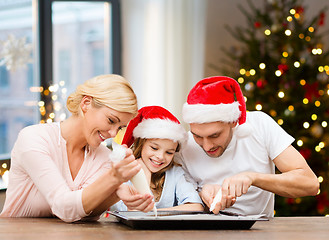 Image showing family decorating bakery by frosting on christmas