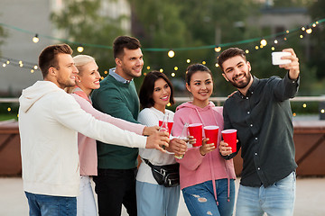 Image showing friends with drinks taking selfie at rooftop party