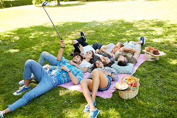 Image showing friends taking picture by selfie stick at picnic