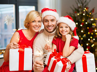 Image showing family with christmas gifts and sparklers at home