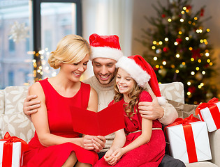 Image showing happy family reading christmas greeting card