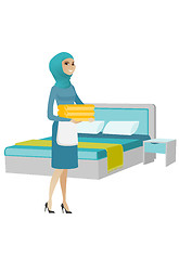 Image showing Muslim housekeeping maid with stack of linen.