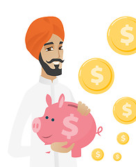 Image showing Hindu businessman holding a piggy bank.