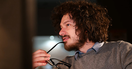 Image showing man working on computer in dark office