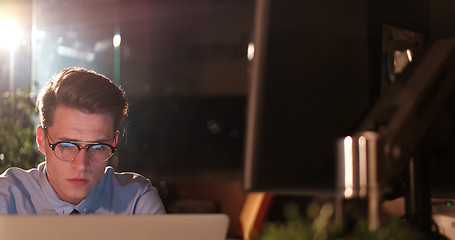 Image showing man working on computer in dark office