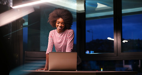 Image showing black businesswoman using a laptop in night startup office