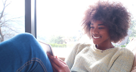 Image showing african american woman at home using digital tablet