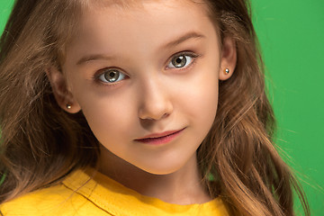 Image showing The happy teen girl standing and smiling against green background.