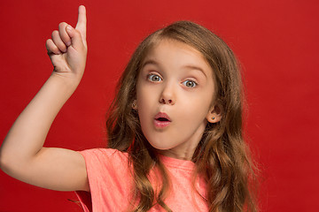 Image showing Beautiful teen girl looking suprised isolated on red