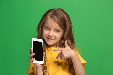 Image showing The happy teen girl standing and smiling against green background.