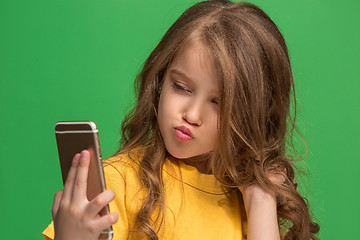 Image showing The happy teen girl standing and smiling against green background.