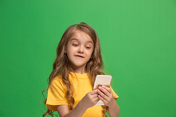 Image showing The happy teen girl standing and smiling against green background.