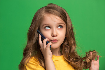 Image showing The happy teen girl standing and smiling against green background.