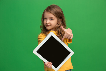 Image showing Little funny girl with tablet on green background