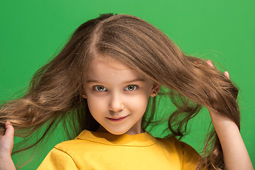 Image showing The happy teen girl standing and smiling against green background.