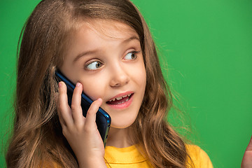 Image showing The happy teen girl standing and smiling against green background.