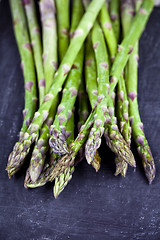 Image showing Organic fresh raw garden asparagus closeup on black board backgr